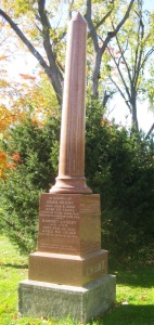 A towering monument by a big old tree to mark the prominence of some long gone family, with the pointed end of the pillar pointing the way to heaven.